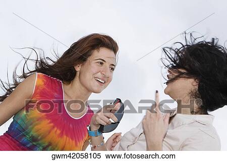 Stock Photography - Side profile of a mid adult woman talking to a young woman. Fotosearch