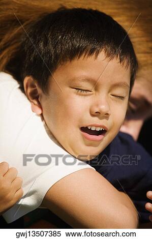 Stock Photography - Side profile of a person hugging a boy. Fotosearch