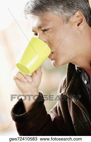Stock Image - Side profile of a senior man drinking coffee. Fotosearch