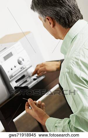 Side profile of a senior man inserting a CD into a CD player View Large Photo Image Stock Photography - Side profile of a senior man inserting a CD into a CD player. Fotosearch