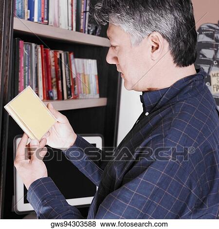 Side profile of a senior man looking at a CD case View Large Photo Image Stock Photo - Side profile of a senior man looking at a CD case. Fotosearch