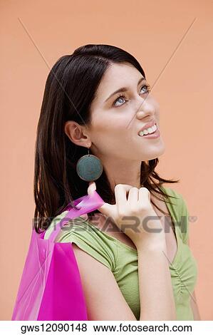 Side profile of a teenage girl holding a shopping bag View Large Photo Image Stock Photo - Side profile of a teenage girl holding a shopping bag. Fotosearch