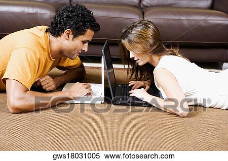 Side profile of a young couple using laptops View Large Photo Image Stock Photography - Side profile of a young couple using laptops. Fotosearch