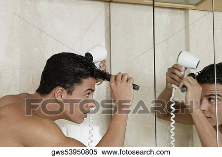 Side profile of a young man drying his hair with a hair dryer in the bathroom View Large Photo Image Stock Photography - Side profile of a young man drying his hair with a hair dryer in the bathroom. Fotosearch