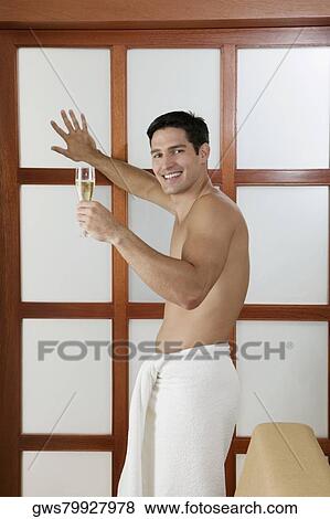 Stock Photo - Side profile of a young man holding a champagne flute. Fotosearch