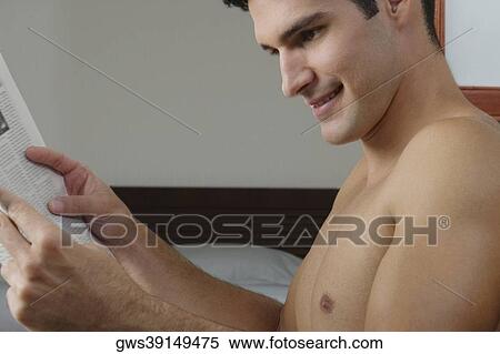 Side profile of a young man reading a newspaper View Large Photo Image Stock Photography - Side profile of a young man reading a newspaper. Fotosearch