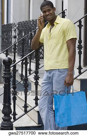 Side profile of a young man standing on the steps and talking on a mobile phone View Large Photo Image Stock Image - Side profile of a young man standing on the steps and talking on a mobile phone. Fotosearch