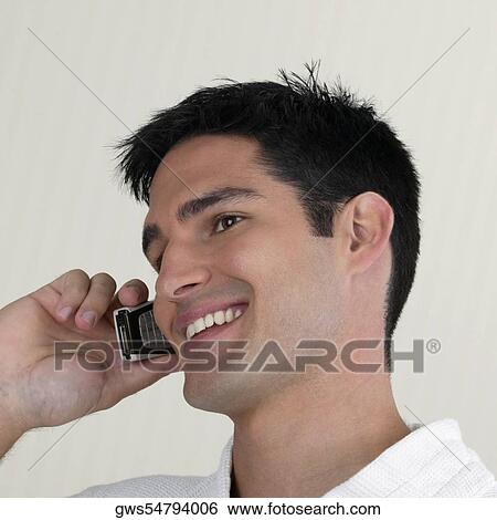 Side profile of a young man talking on a mobile phone View Large Photo Image Stock Photograph - Side profile of a young man talking on a mobile phone. Fotosearch
