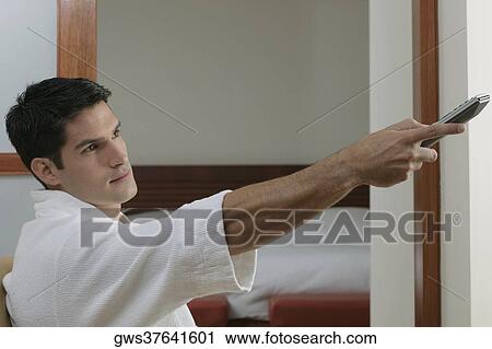 Side profile of a young man using a remote control View Large Photo Image Stock Image - Side profile of a young man using a remote control. Fotosearch