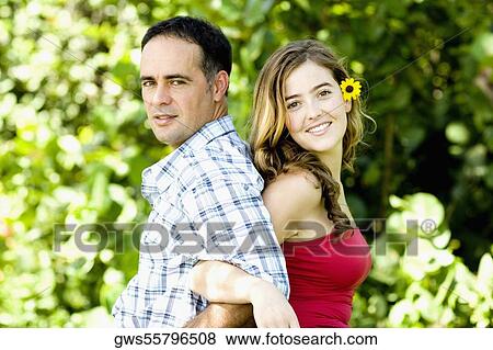 Side profile of a young woman and a mid adult man standing back to back View Large Photo Image Stock Photo - Side profile of a young woman and a mid adult man standing back to back. Fotosearch
