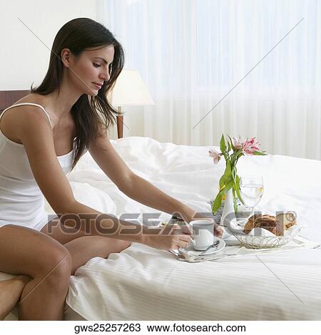Side profile of a young woman having breakfast in bed View Large Photo Image Stock Image - Side profile of a young woman having breakfast in bed. Fotosearch