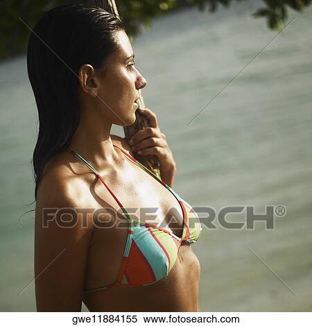 Side profile of a young woman holding a pole View Large Photo Image Stock Photography - Side profile of a young woman holding a pole. Fotosearch