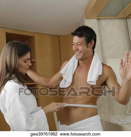 Side profile of a young woman measuring a mid adult man's waist View Large Photo Image Stock Image - Side profile of a young woman measuring a mid adult man's waist. Fotosearch