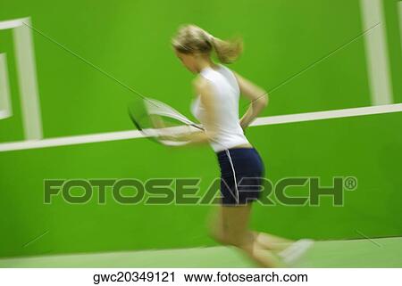Side profile of a young woman playing tennis View Large Photo Image Stock Image - Side profile of a young woman playing tennis. Fotosearch