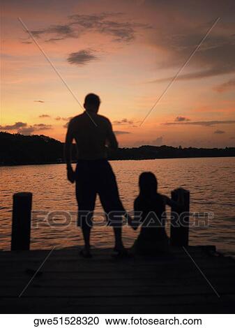 Silhouette of a man and a woman on a pier View Large Photo Image Stock Image - Silhouette of a man and a woman on a pier. Fotosearch