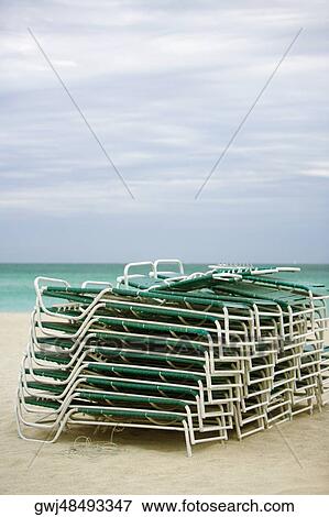 Stack of lounge chairs on the beach View Large Photo Image Stock Photo - Stack of lounge chairs on the beach. Fotosearch