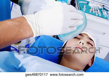 Surgeon's hand putting an oxygen mask on a female patient View Large Photo Image Stock Photo - Surgeon's hand putting an oxygen mask on a female patient. Fotosearch