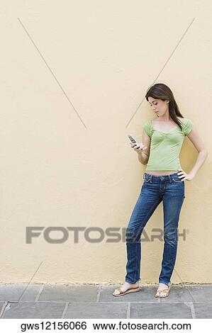 Teenage girl looking at a mobile phone View Large Photo Image Stock Photograph - Teenage girl looking at a mobile phone. Fotosearch