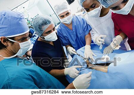 Three female surgeons and two male surgeons operating a patient View Large Photo Image Picture - Three female surgeons and two male surgeons operating a patient. Fotosearch