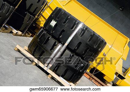 Stock Photo - Tires and crane scoop at the shipping port. Fotosearch