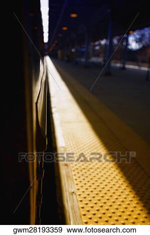 Train at a railroad station platform View Large Photo Image Stock Photo - Train at a railroad station platform. Fotosearch