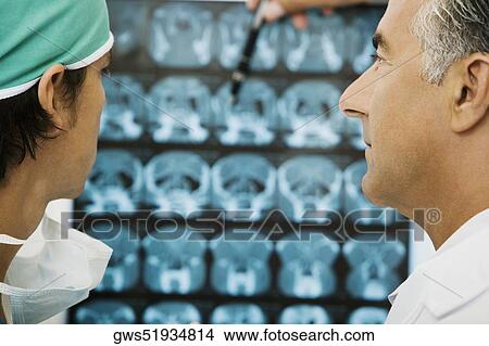 Two male doctors examining an X-Ray View Large Photo Image Picture - Two male doctors examining an X-Ray. Fotosearch