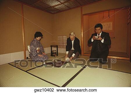 Stock Image - Two men and a woman taking tea, Tokyo Prefecture, Japan. Fotosearch
