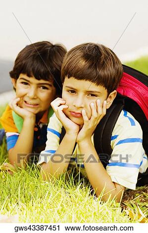 Two schoolboys lying on grass View Large Photo Image Stock Image - Two schoolboys lying on grass. Fotosearch