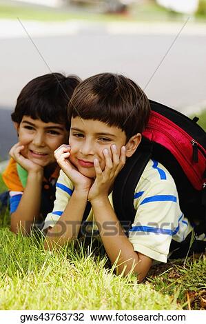 Two schoolboys lying on grass View Large Photo Image Stock Image - Two schoolboys lying on grass. Fotosearch