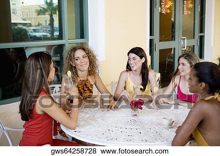 Stock Photo - Two teenage girls and three young women sitting together and gossiping. Fotosearch
