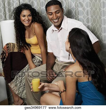 Two young women and a young man sitting together View Large Photo Image Stock Photo - Two young women and a young man sitting together. Fotosearch