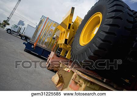 Stock Photography - Vehicle tires and cargo containers at the shipping port. Fotosearch