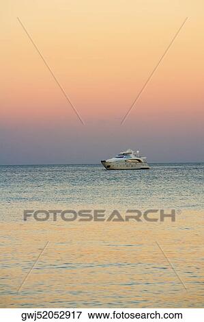 Stock Photo - Yacht in the sea at dusk. Fotosearch