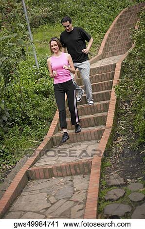 Stock Image - Young couple walking down steps. Fotosearch
