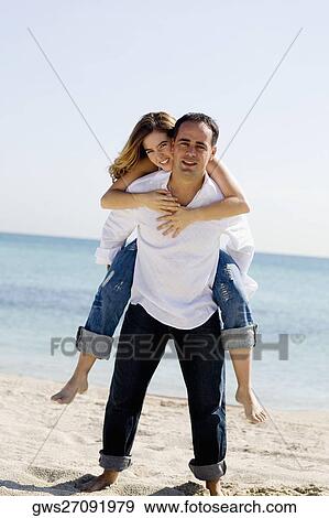 Stock Photo - Young man riding piggyback on a mid adult man. Fotosearch