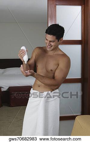Young man squeezing a bottle of moisturizer View Large Photo Image Stock Image - Young man squeezing a bottle of moisturizer. Fotosearch