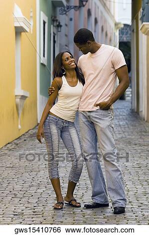 Young man standing with his arm around a teenage girl View Large Photo Image Stock Photograph - Young man standing with his arm around a teenage girl. Fotosearch