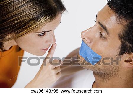 Young man with adhesive tape on his mouth and mid adult woman looking at him View Large Photo Image Stock Photo - Young man with adhesive tape on his mouth and mid adult woman looking at him. Fotosearch