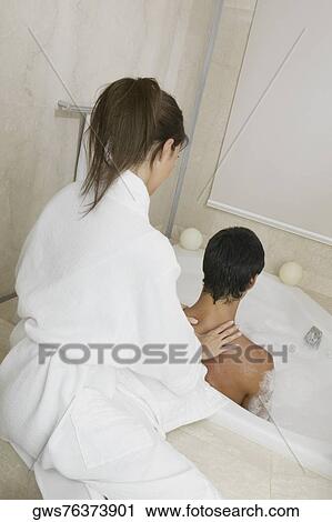 Young woman massaging a mid adult man's shoulders View Large Photo Image Stock Image - Young woman massaging a mid adult man's shoulders. Fotosearch