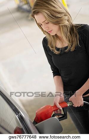 Young woman refueling a car View Large Photo Image Stock Photo - Young woman refueling a car. Fotosearch