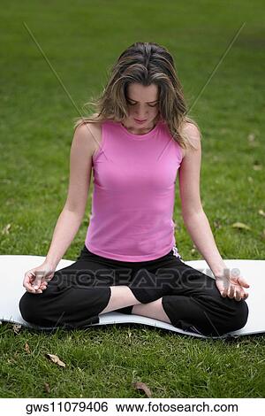 Young woman sitting in the lotus position View Large Photo Image Stock Photograph - Young woman sitting in the lotus position. Fotosearch