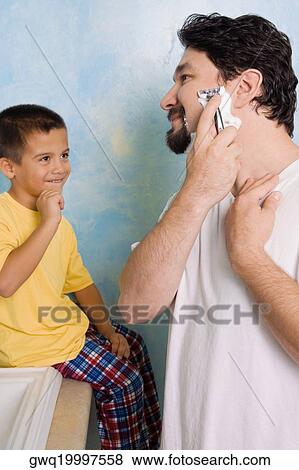 Boy looking at his father shaving in the bathroom View Large Photo Image Stock Photo - Boy looking at his father shaving in the bathroom. Fotosearch