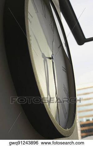 Close-up of a clock hanging on a wall View Large Photo Image Stock Photograph - Close-up of a clock hanging on a wall. Fotosearch