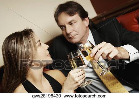 Close-up of a couple toasting with glasses of wine and looking at each other View Large Photo Image Stock Image - Close-up of a couple toasting with glasses of wine and looking at each other. Fotosearch
