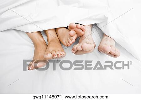 Close-up of a couple's feet with their child on the bed View Large Photo Image Stock Image - Close-up of a couple's feet with their child on the bed. Fotosearch