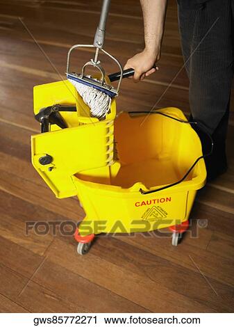 Close-up of a man squeezing a mop View Large Photo Image Stock Image - Close-up of a man squeezing a mop. Fotosearch