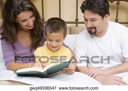 Close-up of a mid adult couple teaching their son View Large Photo Image Stock Photo - Close-up of a mid adult couple teaching their son. Fotosearch