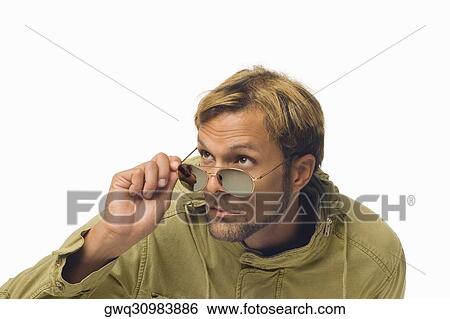 Close-up of a mid adult man peeking over his sunglasses View Large Photo Image Stock Photograph - Close-up of a mid adult man peeking over his sunglasses. Fotosearch