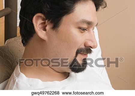 Close-up of a mid adult man reclining on the bed and thinking View Large Photo Image Stock Photo - Close-up of a mid adult man reclining on the bed and thinking. Fotosearch