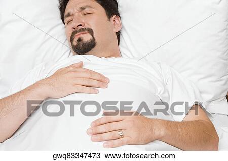 Close-up of a mid adult man sleeping on the bed View Large Photo Image Stock Image - Close-up of a mid adult man sleeping on the bed. Fotosearch